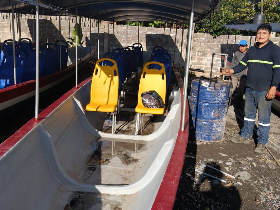 Interior de una canoa de YAKU RUNA con bodega despejada para carga, junto a dos tripulantes